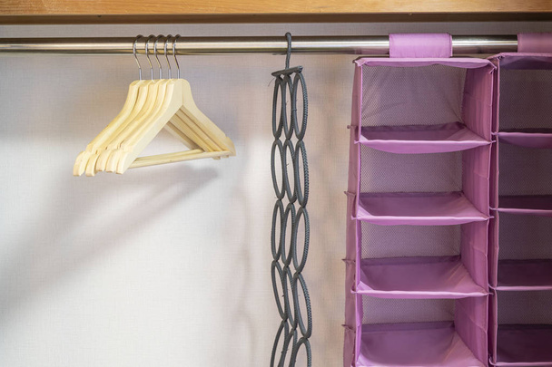 Hangers and plastic clothes storage shelves in the bedroom - Photo, Image