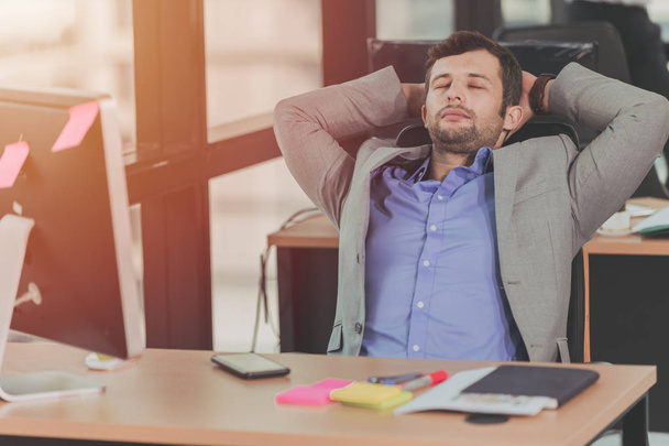 zakenman ontspannen rust NAP na harde werkdag op kantoor - Foto, afbeelding