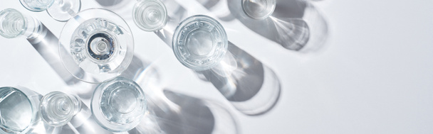 πανοραμική βολή διαφανών γυαλιών με διαυγές νερό σε λευκό φόντο με χώρο αντιγραφής - Φωτογραφία, εικόνα