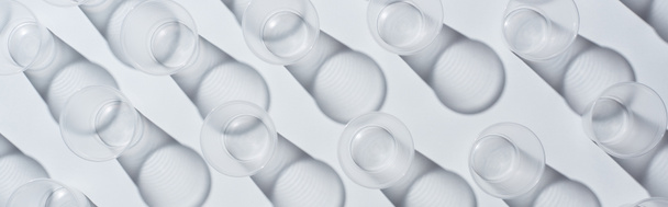 vista superior de vasos vacíos desechables sobre fondo blanco con sombras, plano panorámico
 - Foto, Imagen