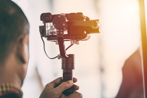 Videographer recording video with mirrorless digital camera on Gimbal Stabilization system - Фото, зображення
