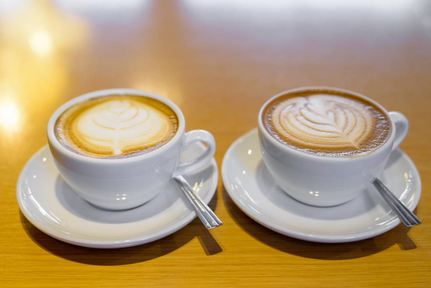 Классический латте кофе и кафе мокко подается на деревянном столе в белых чашках
 - Фото, изображение