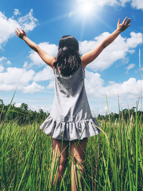 Jovem mulher na grama verde espalhando braços para o céu
. - Foto, Imagem