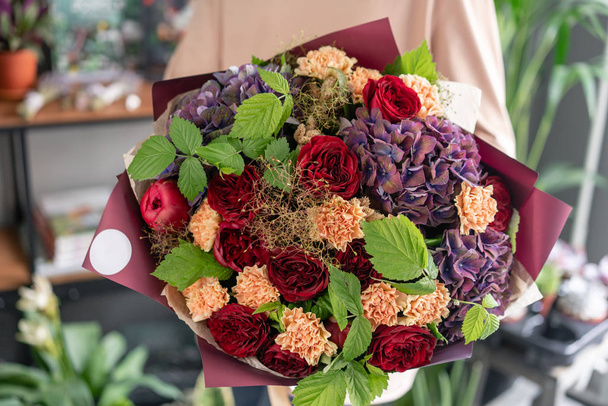 女性の手に混合花の大きな美しい花束。フローラルショップコンセプト.美しい新鮮なカットブーケ。花の配達 - 写真・画像