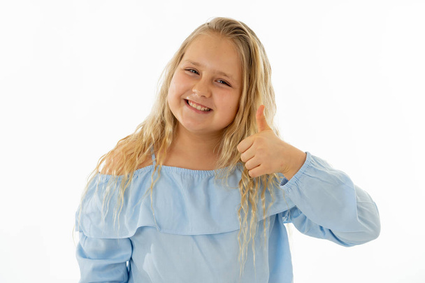 Portrait of young schoolgirl feeling happy smiling and making thumbs up gesture. Isolated on neutral background. In Education Children, Human expressions and body language. - Foto, Bild
