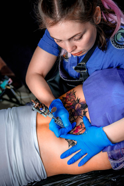 Professional tattooer makes tattoo pictures in tattoo parlour - Photo, Image