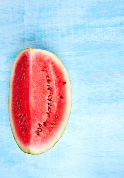 cut of watermelon on blue background. Top view, flat lay. Vertical image. - Φωτογραφία, εικόνα