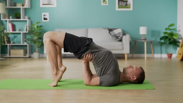 Jongeman die 's morgens yoga doet in zijn woonkamer - Video