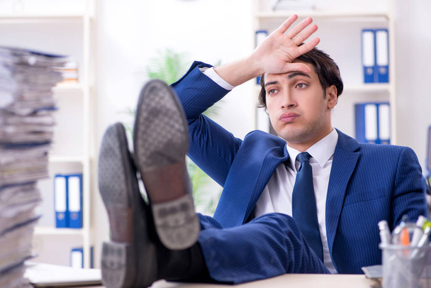 Jovem funcionário do sexo masculino infeliz com trabalho excessivo - Foto, Imagem