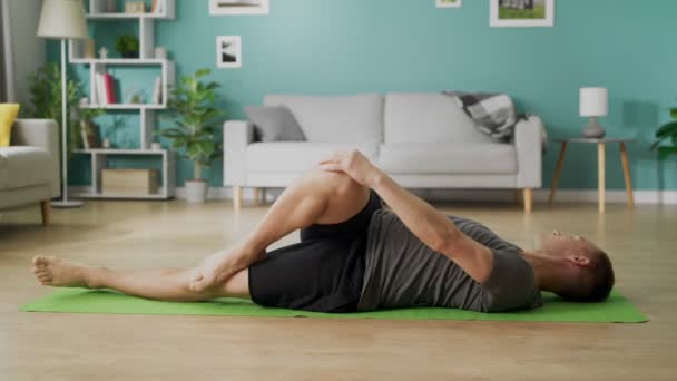 Giovane che fa yoga al mattino nel suo soggiorno
 - Filmati, video