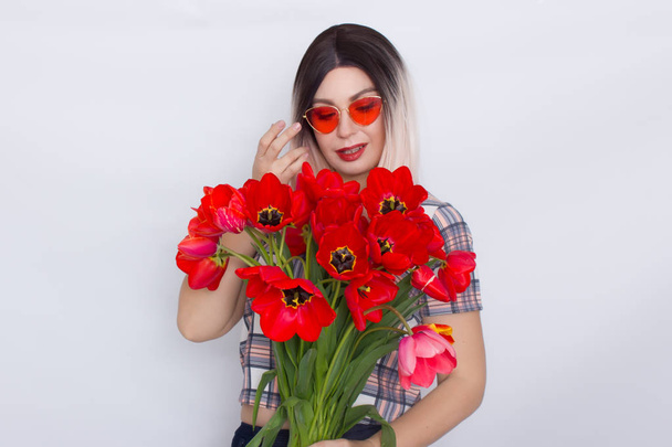 Blonde woman holding bouquet of red tulips - Foto, imagen