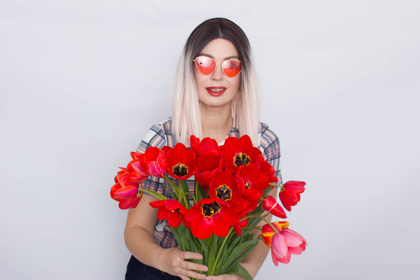 Blonde woman holding bouquet of red tulips - Fotoğraf, Görsel