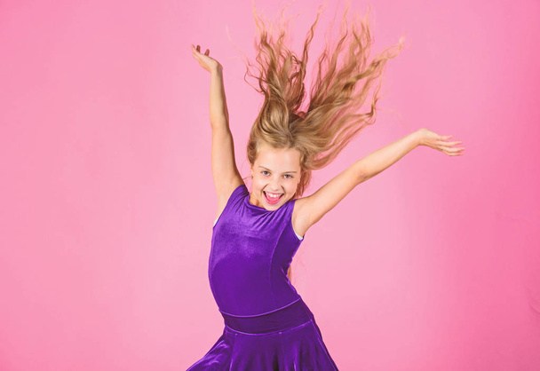 Ballroom latin dance hairstyles. Kid girl with long hair wear dress on pink background. Things you need know about ballroom dance hairstyle. Hairstyle for dancer. How to make tidy hairstyle for kid - Фото, изображение