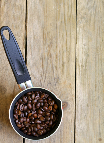 Kahvipavut ja punainen kahvipannu puupöydällä
 - Valokuva, kuva
