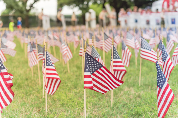 Οι σημαίες των Αμερικάνων με θολές σειρές ανθρώπων μεταφέρουν Έκπτωτους στρατιώτες να παρελαύνουν - Φωτογραφία, εικόνα