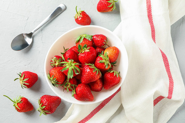 Plate with fresh strawberries, spoon and kitchen towel on white  - Foto, immagini