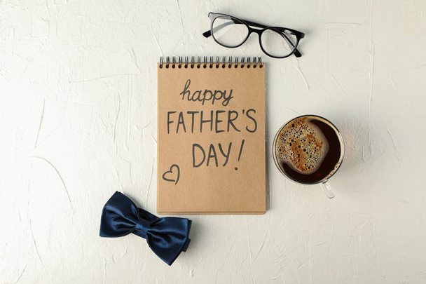 Notitieboekje met inscriptie Happy Fathers Day, blauw strikje, Cup o - Foto, afbeelding