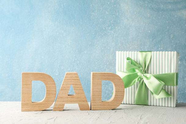 Gift box with green ribbon and inscription DAD on white table ag - Фото, зображення