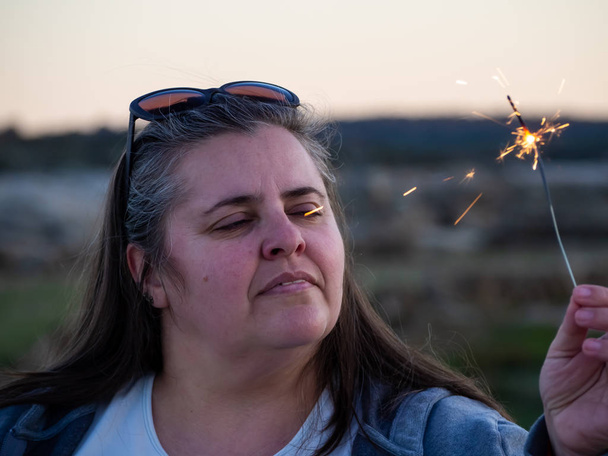 Une femme courbée adulte avec une fusée éclairante dans sa main
 - Photo, image