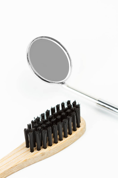 Бамбуковая зубная щетка и зеркало дантиста
 - Фото, изображение