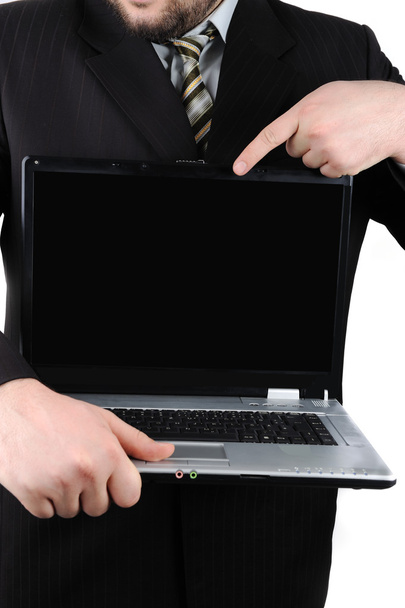 Smiling young businessman holding laptop with blank screen and showing thu - Фото, зображення