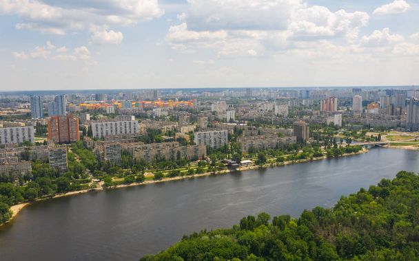 Urban aerial view photo from drone of cityscape, skyline and coastline of Dnieper River near Rusanivka island at summer time. (Kyiv, Kiev) Ukraine. - Photo, Image