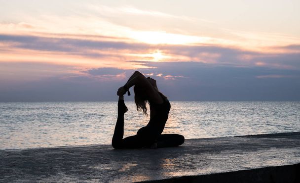tunnistamaton senoir nainen kaunis elin tekee jooga halkeaa auringonnousun merellä, siluetti jooga aiheuttaa
 - Valokuva, kuva