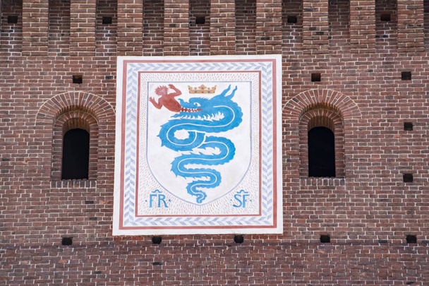 Milan, Italy, Europe, 03/28/2019: view of the biscione, an azure serpent in the act of consuming a human, the emblem of the House of Visconti and of the city from the 11th century, on the Filarete Tower of the Sforza Castle (Castello Sforzesco) - Photo, Image