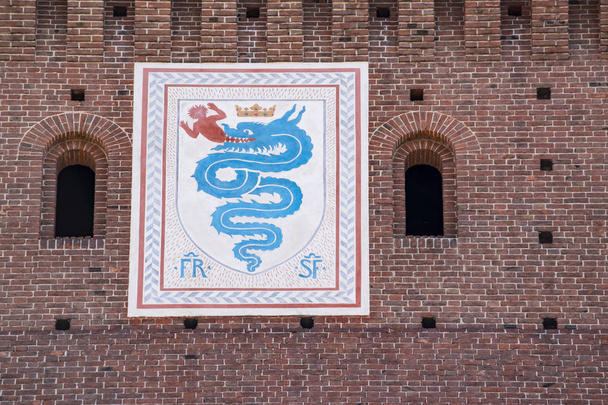 Milan, Italy, Europe, 03/28/2019: view of the biscione, an azure serpent in the act of consuming a human, the emblem of the House of Visconti and of the city from the 11th century, on the Filarete Tower of the Sforza Castle (Castello Sforzesco) - Photo, Image