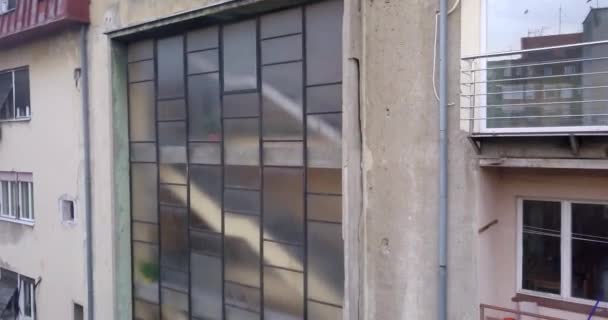 Drone wordt aflopend weergegeven buitenkant van een oud gebouw met ramen reflectie in Novi Sad - Video