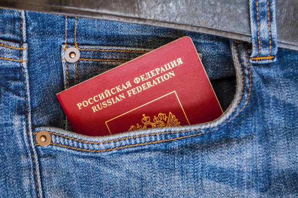 Rusya'nın kırmızı pasaportu bir cebinden mavi kot pantolon ala. Rus pasaportu, Rus turist seyahat konsepti görüntü. - Fotoğraf, Görsel