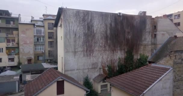 Drone is lifting up and reviling old damage buildings with part of facade missing and dirty roofs in Novi Sad  - Footage, Video