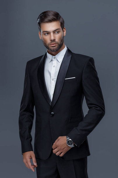 όμορφος άντρας με ένα μοντέρνο κούρεμα με μαύρο παλτό, μαύρο πουκάμισο - Φωτογραφία, εικόνα