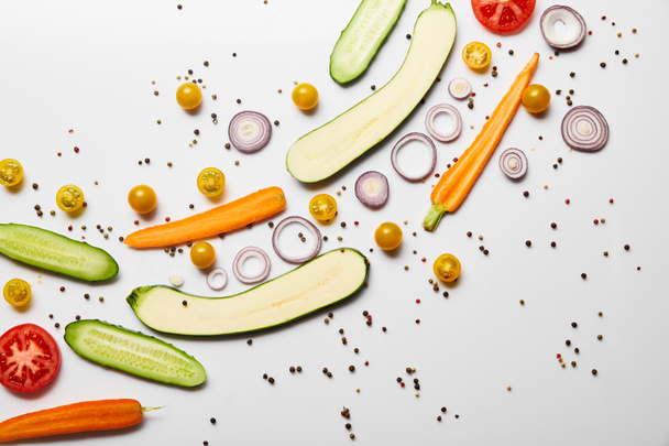 bovenaanzicht van verse gesneden groenten en specerijen op witte achtergrond met kopieerruimte - Foto, afbeelding