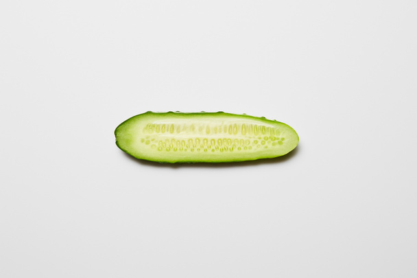 bovenaanzicht van verse komkommer slice op witte achtergrond - Foto, afbeelding