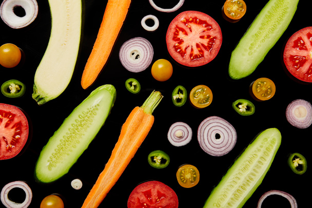 top view of fresh ripe sliced vegetables isolated on black - Foto, imagen