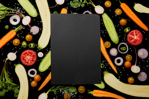 top view of empty black card on vegetable pattern isolated on black - Photo, Image