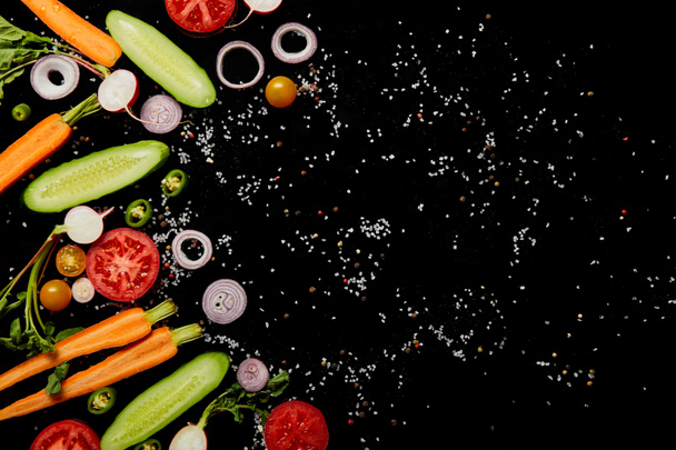 top view of fresh vegetable slices with salt isolated on black with copy space - Foto, Imagem