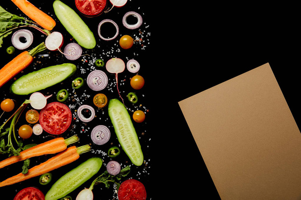 vue du dessus des tranches de légumes frais avec sel près du papier brun blanc isolé sur noir avec espace de copie
 - Photo, image