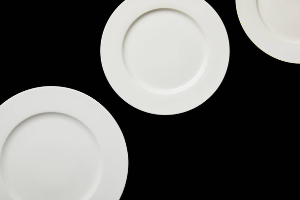 top view of white empty round plates isolated on black - Photo, image