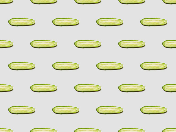 bovenaanzicht van komkommer Slices op witte achtergrond, naadloos patroon - Foto, afbeelding