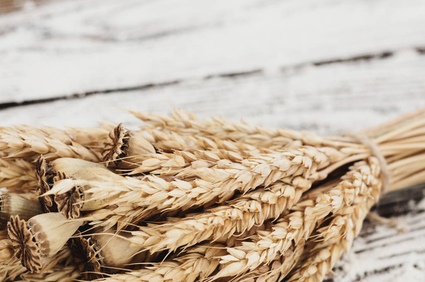 Jeden uzlík z pšenice a máky a poseté mouky na starých rustikálních dřevěných prkně - Fotografie, Obrázek