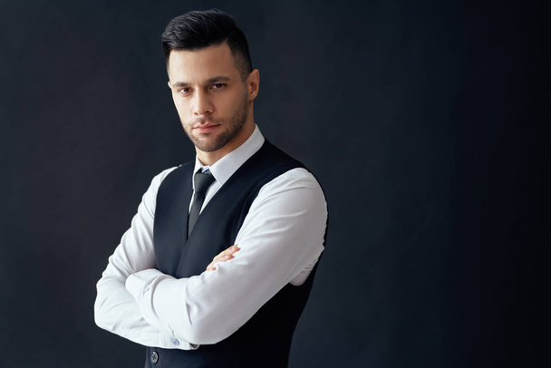 Handsome confident man in elegant suit with crossed arms on black background and copy space                               - Fotoğraf, Görsel