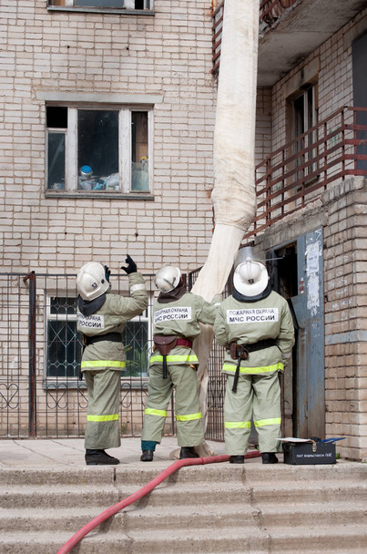 Brandweerlieden evacueren bewoners met behulp van een brand Rescue-apparaat - Foto, afbeelding