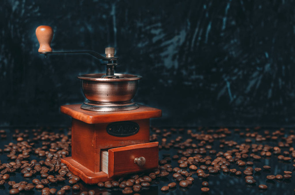 Old wooden coffee grinder and coffee beans on concrete background. - Photo, image