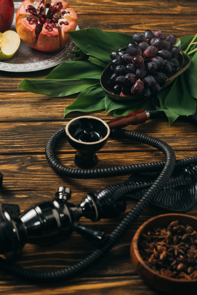 selective focus of hookah and fresh fruits on wooden surface - Foto, afbeelding