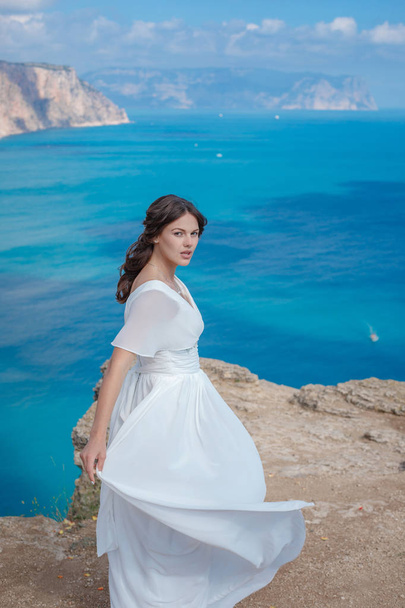 Une belle mariée debout sur la côte. La mariée dans les montagnes. Mariage
 - Photo, image