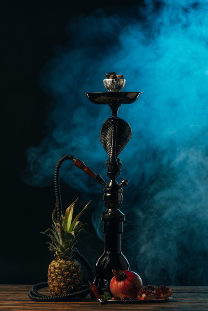 hookah with exotic fruits on wooden surface in blue smoke - Foto, Imagem