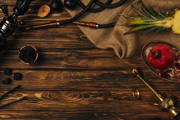Κορυφαία θέα από φρέσκα φρούτα, κάρβουνα και χουλέ σε ξύλινη επιφάνεια - Φωτογραφία, εικόνα