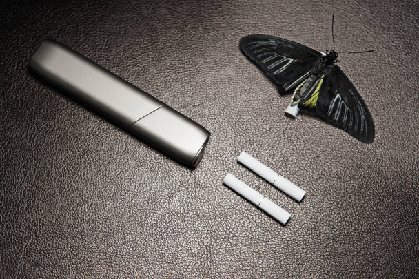 electronic smoke device butterfly leather background  - Valokuva, kuva